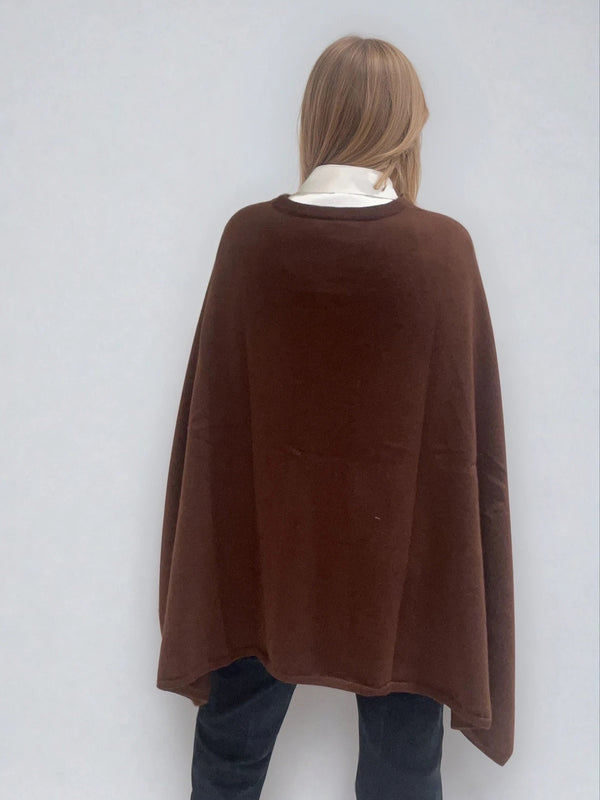 Pull coloris chocolat avec une encolure ronde.  Le modèle est un pull cape: le corps du pull est sans manches, une cape a été associée au niveau des manches raglan devant pour donner un effet chauve-souris . Les bras sont recouverts grâce aux pans de la cape. Vue dos.