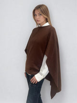 Pull coloris chocolat avec une encolure ronde.  Le modèle est un pull cape: le corps du pull est sans manches, une cape a été associée au niveau des manches raglan pour donner un effet chauve-souris . Les bras sont recouverts grâce aux pans de la cape. Vue profil.