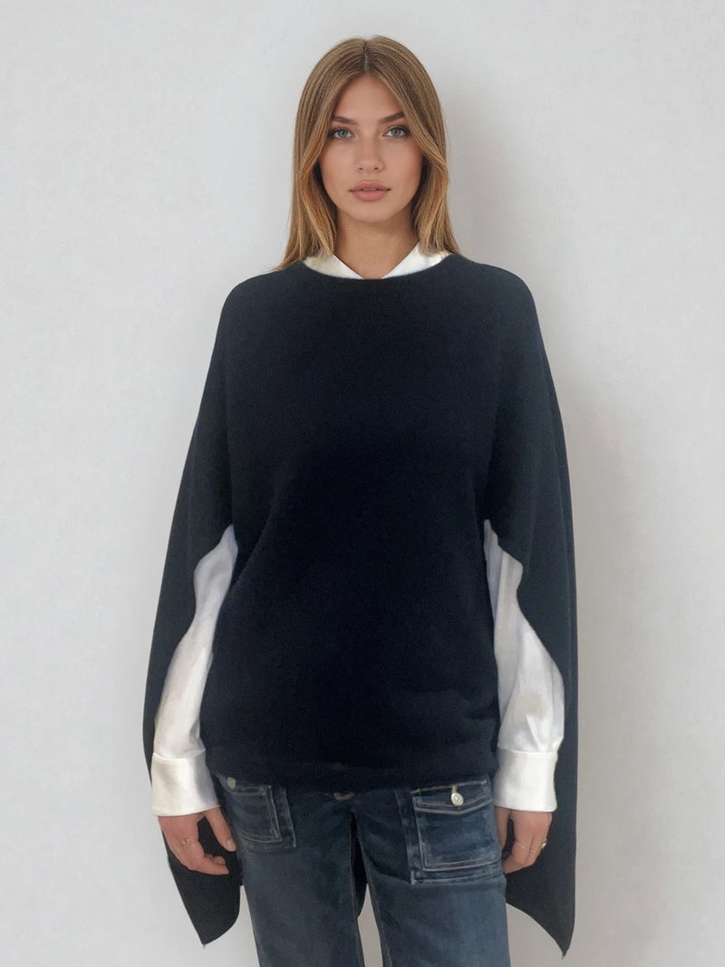 Pull coloris marine avec une encolure ronde.  Le modèle est un pull cape: le corps du pull est sans manches, une cape a été associée au niveau des manches raglan devant pour donner un effet chauve-souris . Les bras sont recouverts grâce aux pans de la cape. Vue face.
