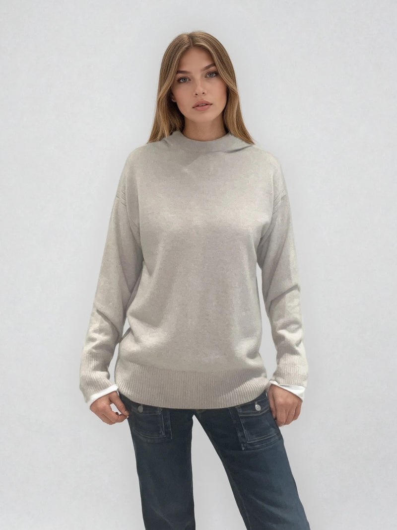 Pull beige en 100%cachemire, manches longues avec une encolure ronde rehaussée d'une capuche. Coupe droite, esprit hoody, se porte assez vague. Les emmanchures sont basses. Un élégant travail de maille formé de 2 bandes termine chaque couture d'assemblage. Finitions côtes.