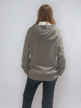 Pull taupe en 100% cachemire, manches longues avec une encolure ronde rehaussée d'une capuche. Coupe droite, esprit hoody, se porte assez vague. Les emmanchures sont basses. Un élégant travail de maille formé de 2 bandes termine chaque couture d'assemblage. Finitions côtes. Vue dos.