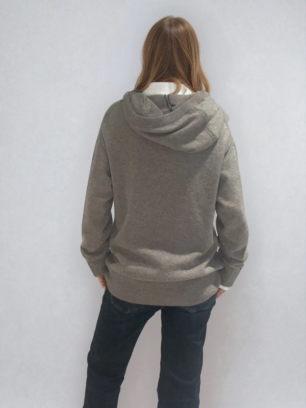 Pull taupe en 100% cachemire, manches longues avec une encolure ronde rehaussée d'une capuche. Coupe droite, esprit hoody, se porte assez vague. Les emmanchures sont basses. Un élégant travail de maille formé de 2 bandes termine chaque couture d'assemblage. Finitions côtes. Vue dos.