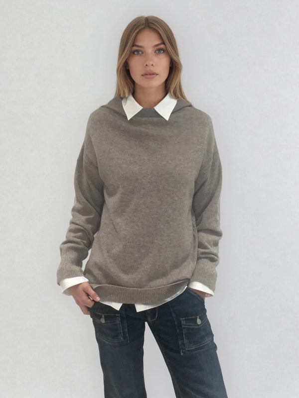 Pull taupe en 100% cachemire, manches longues avec une encolure ronde rehaussée d'une capuche. Coupe droite, esprit hoody, se porte assez vague. Les emmanchures sont basses. Un élégant travail de maille formé de 2 bandes termine chaque couture d'assemblage. Finitions côtes. Vue face.