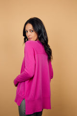 Pull manches longues, col V, coloris rose vif avec une encolure V, la coupe est oversize. Une couture horizontale dans le haut du dos apporte de l'aisance. Fente sur les côtés, le pull est plus long derrière. Finitions côtes sur le bas et les manches. Taille unique.
45% de cachemire et 55% de laine mérinos. Vue dos.