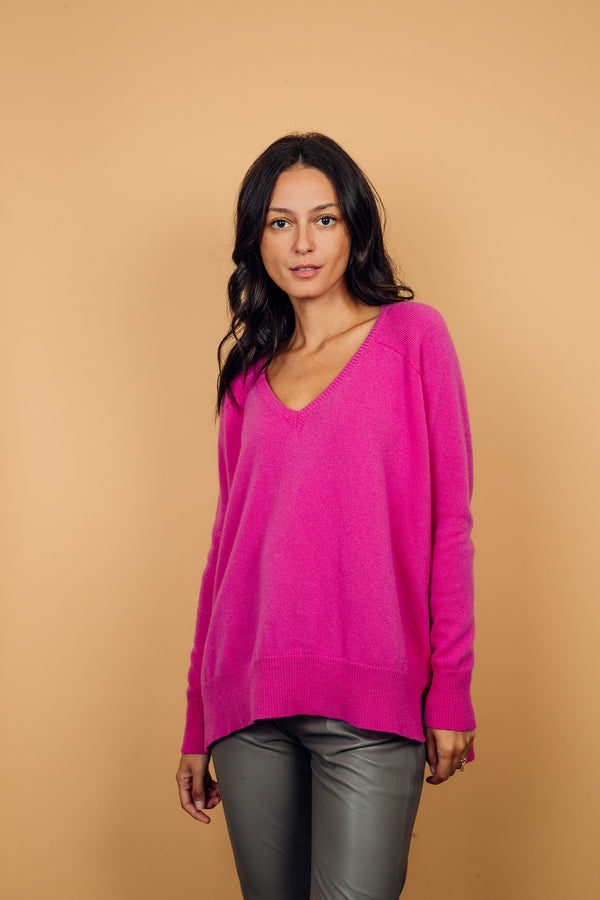 Pull manches longues, col V, coloris rose vif avec une encolure V, la coupe est oversize. Fente sur les côtés et le pull est plus long derrière. Finitions côtes sur le bas et les manches. Taille unique.
 45% de cachemire et 55% de laine mérinos.
