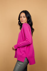 Pull manches longues, col V, coloris rose vif avec une encolure V, la coupe est oversize. Une couture horizontale dans le haut du dos apporte de l'aisance. Fente sur les côtés, le pull est plus long derrière. Finitions côtes sur le bas et les manches. Taille unique.
45% de cachemire et 55% de laine mérinos. Vue  profil.