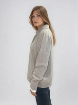 Pull polo beige en 42% cachemire, 8% soie, 50% mérinos. Le polo a un col large et ouvert avec 3 boutons. La coupe est droite et confort. Finitions côtes. Vue profil.