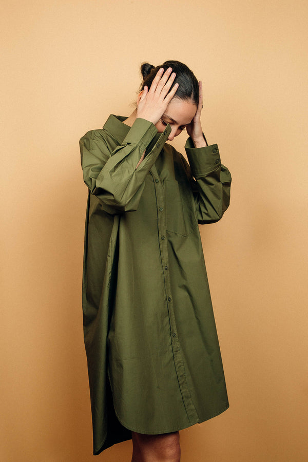 Robe chemise kaki oversize en 100%coton, manches longues.
La robe est légèrement plus courte devant, elle arrive au dessus du genou, elle est largement fendue de chaque côté, la fente est arrondie. Les manches longues sont amples et se terminent par un grand poignet mousquetaire. Boutonnage de haut en bas. 1 poche poitrine.