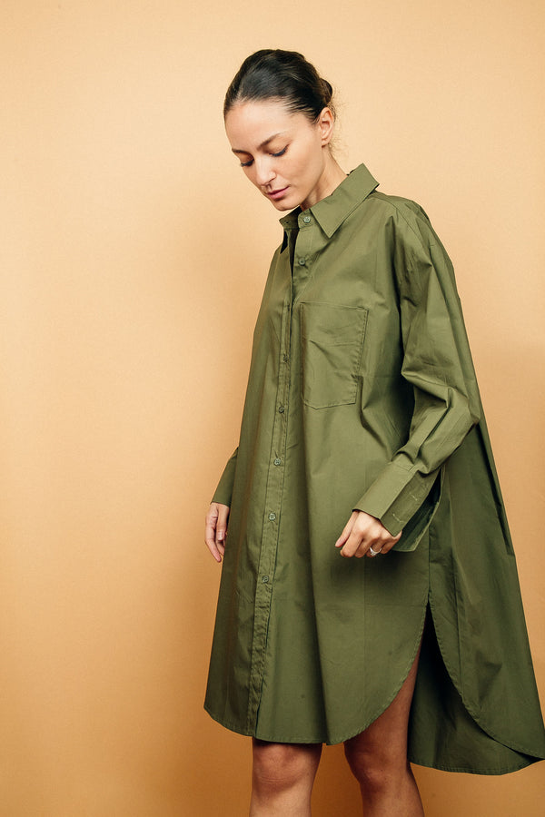 Robe chemise kaki oversize en 100%coton, manches longues.
La robe est légèrement plus courte devant, elle arrive au dessus du genou, elle est largement fendue de chaque côté, la fente est arrondie. Les manches longues sont amples et se terminent par un grand poignet mousquetaire. Boutonnage de haut en bas. 1 poche poitrine.