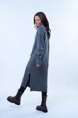 Robe pull manches longues grise avec un col V. Elle est longue et arrive aux mollets. Elle est fendue sur les côtés pour mieux se déplacer. Allure sport chic, confortable et chaude : 42% cachemire, 8% soie, 50% mérinos. Détail fente.