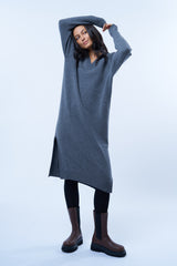 Robe pull manches longues grise avec un col V. Elle est longue et arrive aux mollets. Elle est fendue sur les côtés pour mieux se déplacer. Allure sport chic, confortable et chaude : 42% cachemire, 8% soie, 50% mérinos.