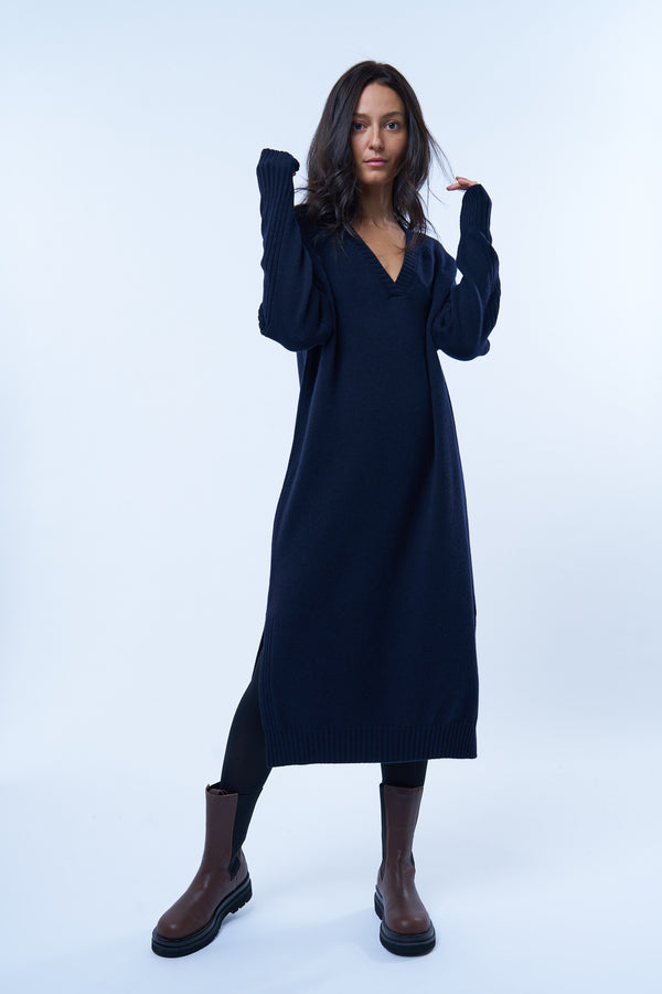 Robe pull manches longues marine avec un col V. Elle est longue et arrive aux mollets. Elle est fendue sur les côtés pour mieux se déplacer. Allure sport chic, confortable et chaude : 42% cachemire, 8% soie, 50% mérinos.