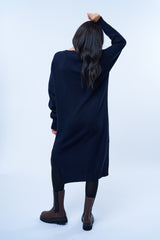 Robe pull manches longues marine avec un col V. Elle est longue et arrive aux mollets. Elle est fendue sur les côtés pour mieux se déplacer. Allure sport chic, confortable et chaude : 42% cachemire, 8% soie, 50% mérinos. Vue dos.