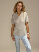 Tee-shirt manches courtes col V beige en viscose mélangée. La forme est droite, le col V, les manches et le bas sont terminés par des côtes. Le tissage donne un effet relief à la texture. Tee-shirt élégant et épuré.
Vue face.