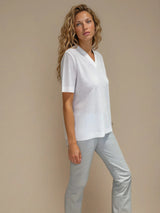 Tee-shirt manches courtes col V blanc en viscose mélangée. La forme est droite, le col V, les manches et le bas sont terminés par des côtes. Le tissage donne un effet relief à la texture. Tee-shirt élégant et épuré.
Vue profil.