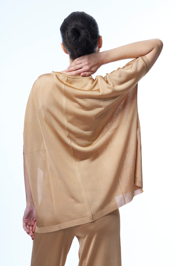T-shirt long couvrant le bas du dos avec une coupe oversize. Manches courtes qui tombent sur les avant-bras, fentes sur les côtés d'environ 15 cm, viscose fluide. Coloris doré uni légèrement brillant.Vue dos avec le pantalon en viscose assorti.