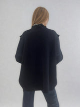 Veste marine en cachemire, soie et mérinos. La coupe est large, des franges en maille ornent l'encolure. Les emmanchures sont basses. Veste confortable. Vue dos.
