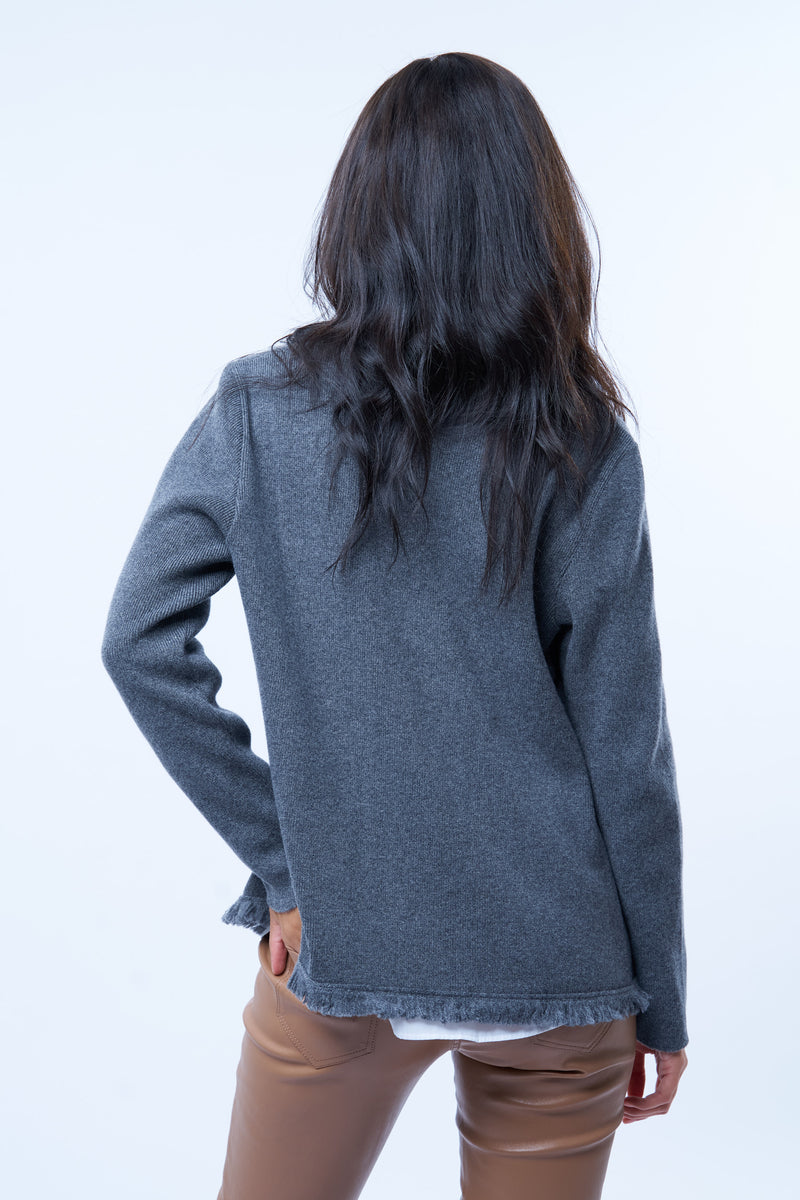 Veste manches longues grise en cachemire, laine et mérinos. La veste est bordée tout le long du col tailleur et en bas de petites franges grises en laine, se ferme avec 1 bouton et a  2 fausses poches sur les côtés. Coupe droite. Vue dos.